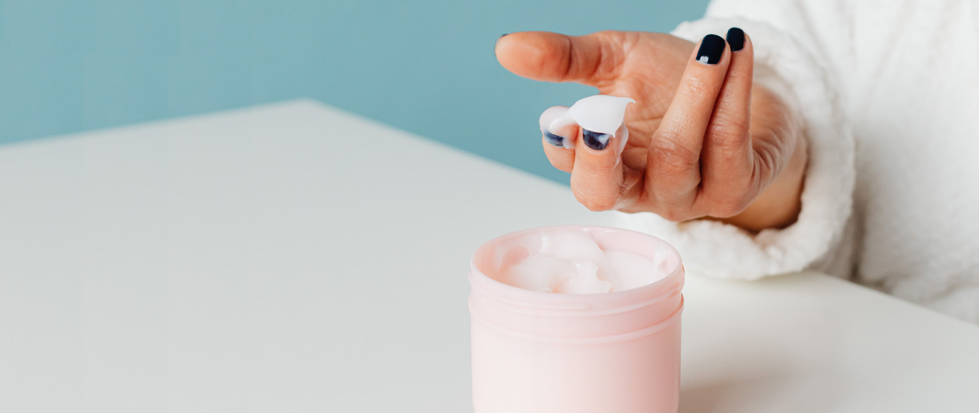 woman's hand using cream