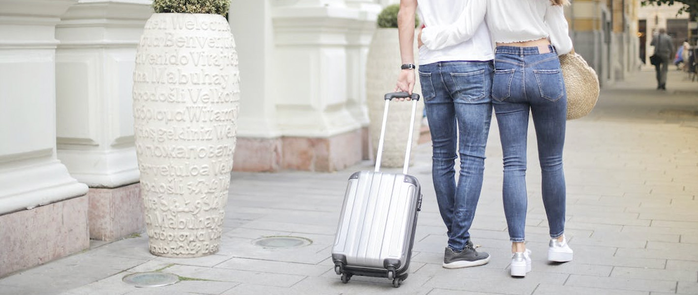 couple with suitcase walking away