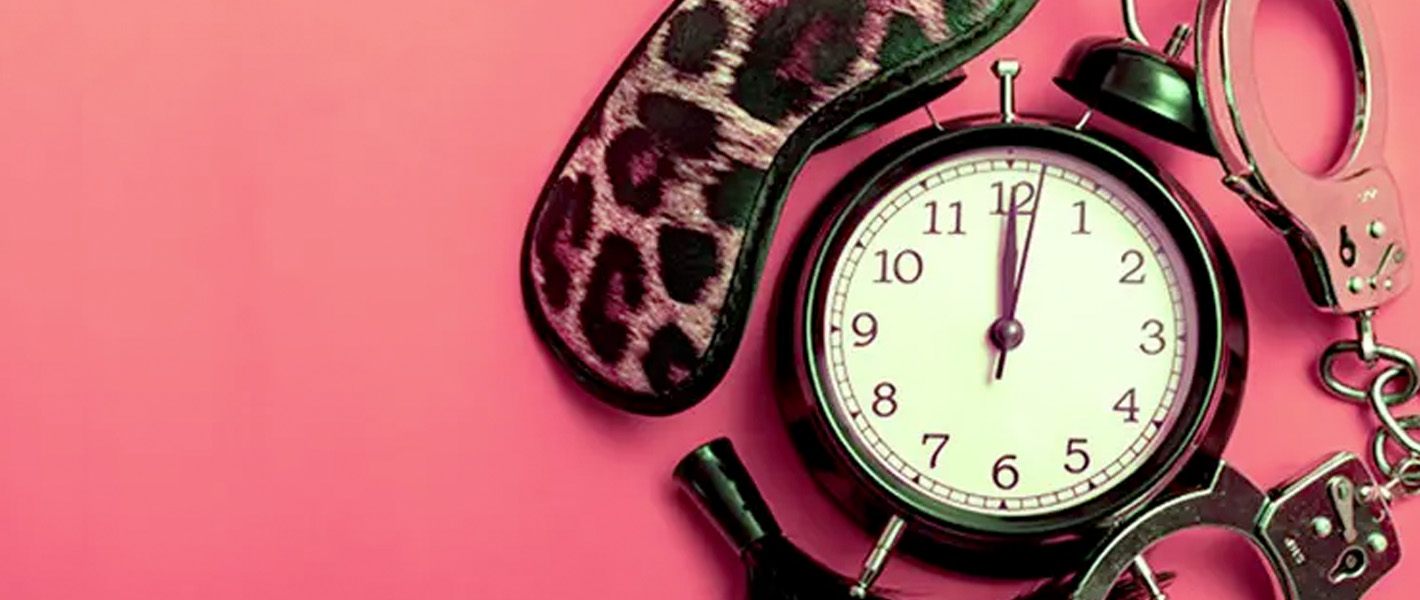 sex toys and clock on pink background