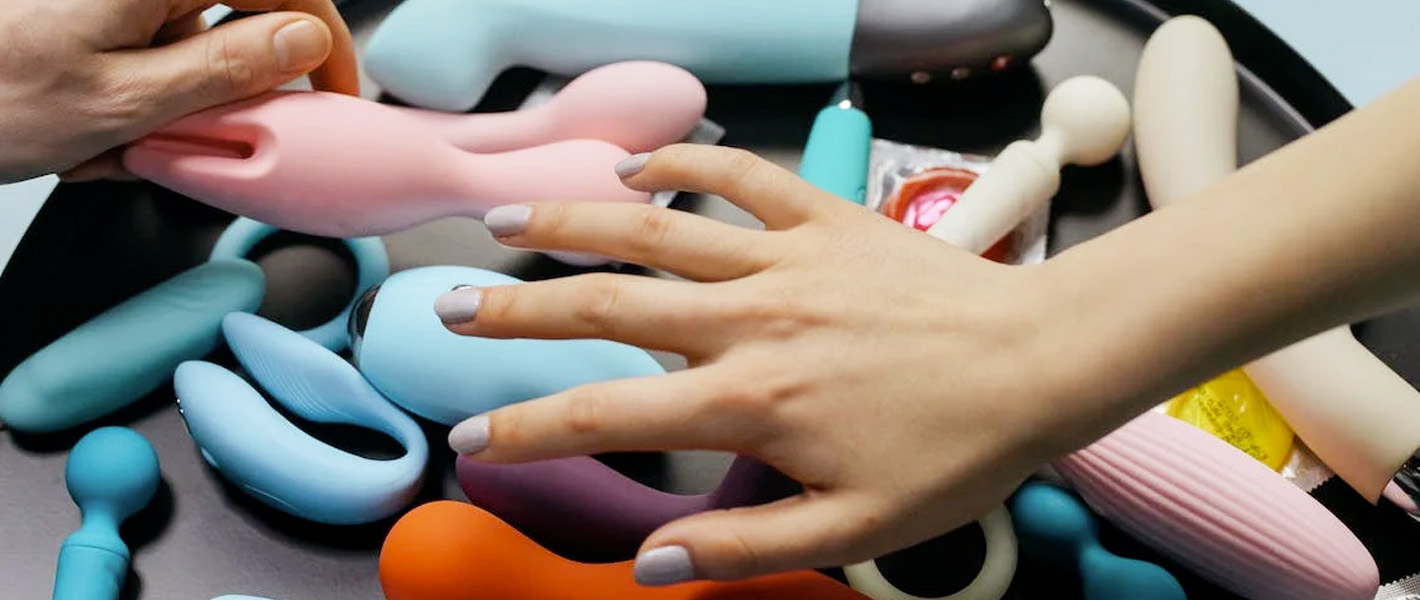 hand hovering over a selection of sex toys